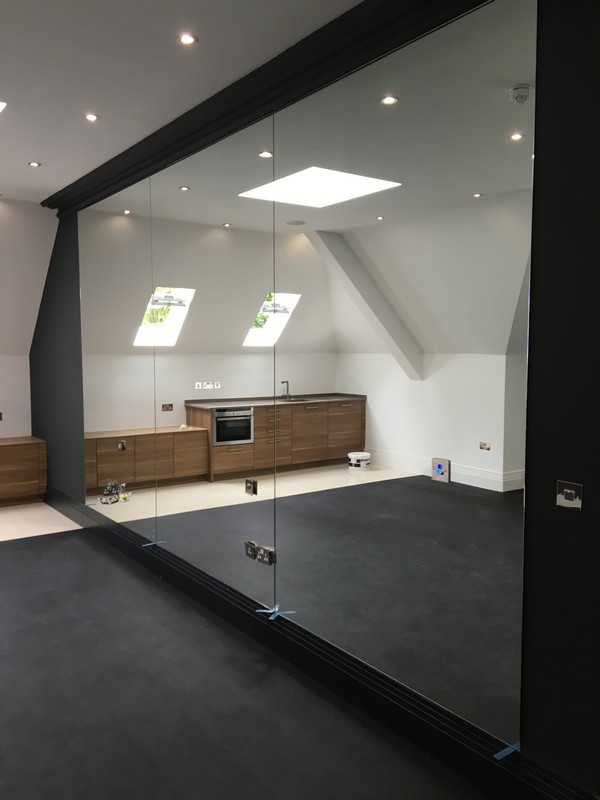 Frameless glass partition in loft conversion by Sydenham glaziers